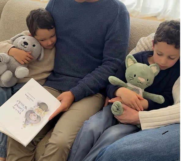 Two children reading The Good Witch storybook with Rune and Indi comfort toys